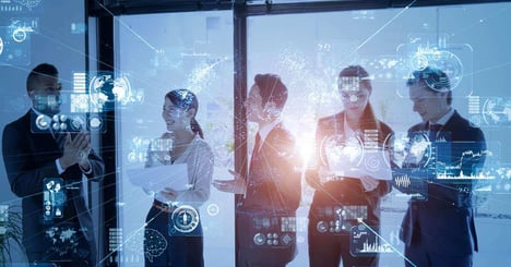 Employees gather around and study an AI generated screen with holograms of data sets for their company