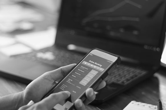 Businessman-using-mobile-smartphone-with-data-information-banking-network-connection-on-screen,-mobile-banking-and-online-payment.-1182616143_5000x3333-grayscale