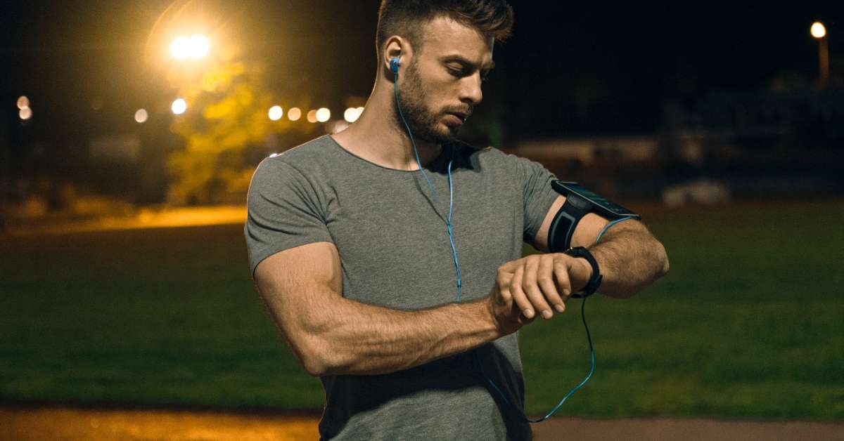 Military personnel stands and checks his vitals on his smart watch.