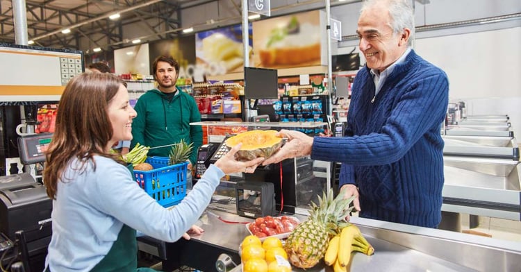 A woman purchases an item from a store associate using an identity based discount showcasing her loyalty and the company's improved marketing strategy. 