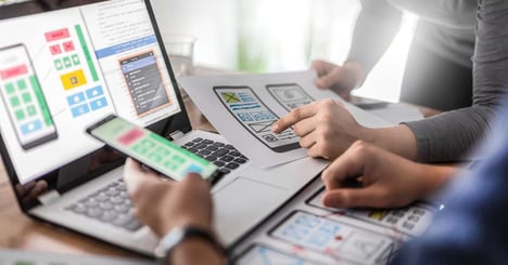 Image of a person holding a tablet with a online grocery management system while standing in a grocery aisle.
