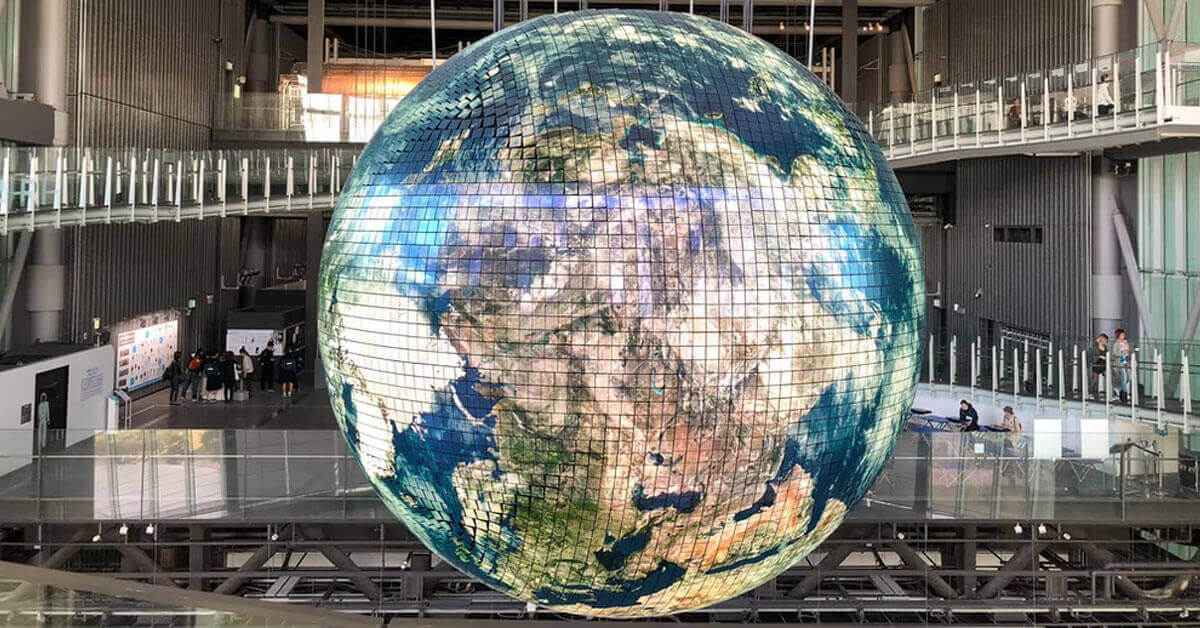 A giant model of a globe hangs from a ceiling