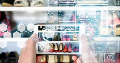 Person holds a mobile device with AI generated fashion image suggestions.